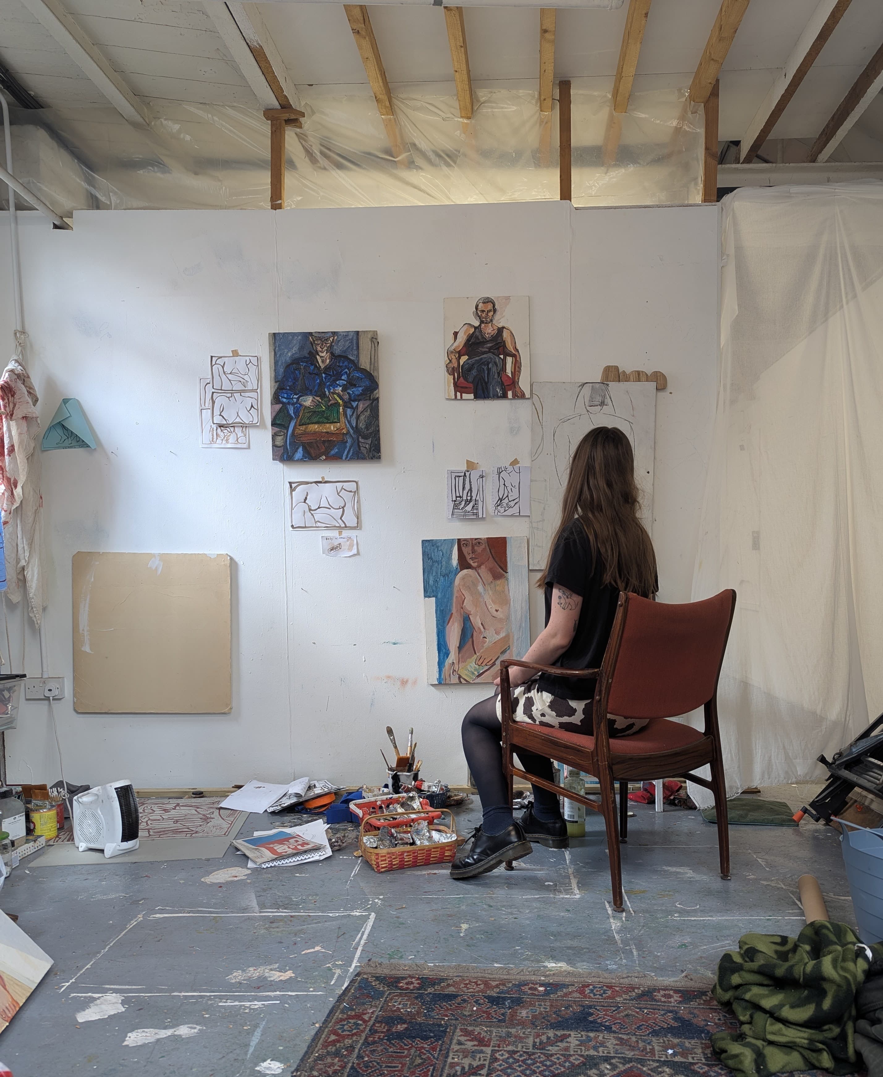 Portrait of artist sitting at their chair in their studio.